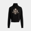 Winter Capsule Rollkragenpullover Aus Schwarzer Wolle Mit Einer Heritage-Blume